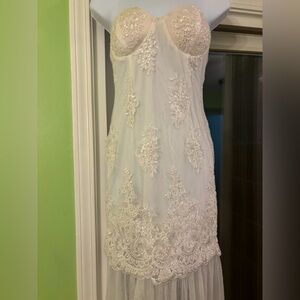 White strapless embellished gown with feathered train.